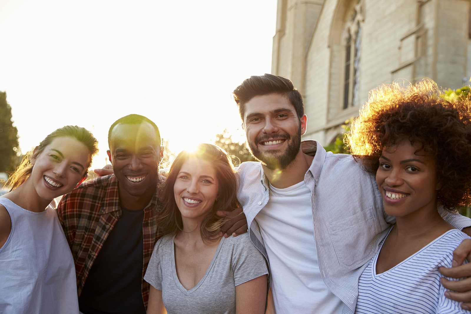 Group of smiling young adult friends embracing in the street We Are Thankful for You, Edna